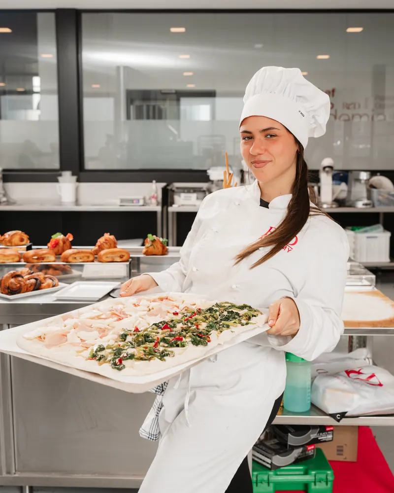 Allieva ReD Academy con una teglia di focaccia farcita nel laboratorio