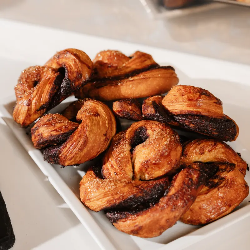 Treccine di pasta sfogliata lievitata al cacao, con zucchero in superficie