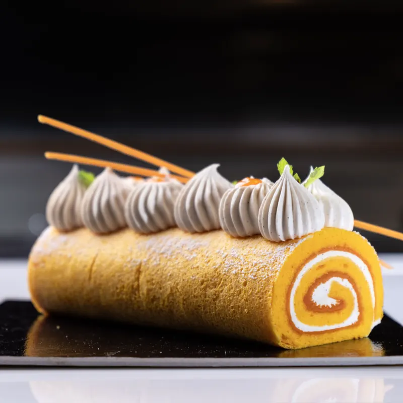 Rotolo all&rsquo;arancia con ciuffi di crema e foglie di menta