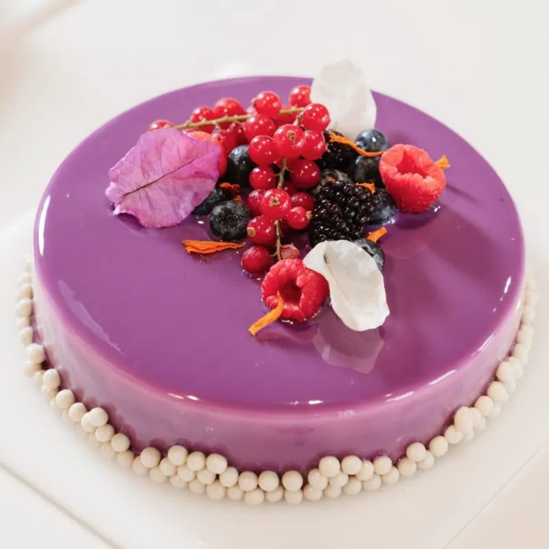 Torta con glassa viola a specchio e frutti di bosco