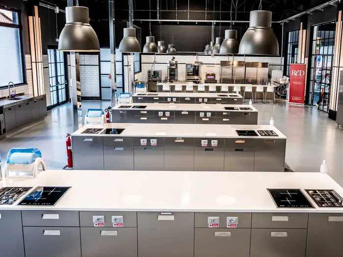 Vista d'insieme del loft di cucina con le isole di lavoro e il soffitto industriale
