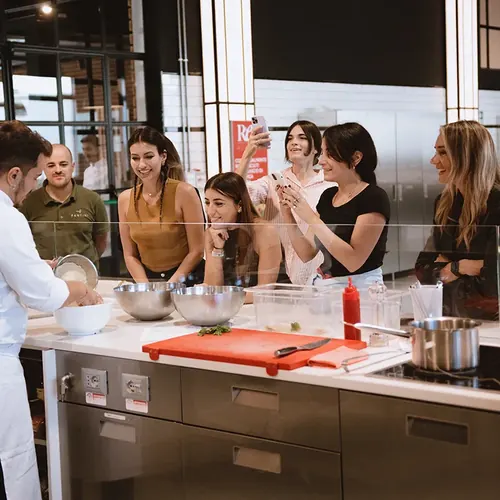 Un gruppo segue la dimostrazione dello chef al bancone