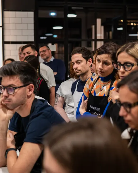 Il gruppo in grembiule ascolta le indicazioni prima di andare alle postazioni